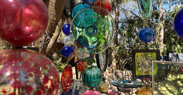 Hand blow glass ornaments hang from trees outside in the cafe at Kitengela Glass, Nairobi, Kenya