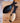 Two wooden spoons with black ends on a wooden surface.