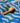 Wooden brush with black bristle head on a blue wavy patterned surface