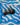 Black spoon on a blue and white wavy-patterned surface