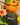 Gold necklace on a rock with a pumpkin and flowers in the background