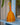 Woven rattle with orange and yellow pattern on a blue shelf
