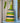 Woven rattle shaker with green, blue, and beige stripes on a light blue surface.