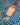 Wooden scoop filled with oats on a blue and white patterned surface