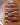 Wooden cutting board with a multicolored pattern on a wooden surface.