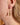 Close-up of a person wearing a gold crescent moon earring.