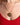 Gold necklace with a circular mixed metal pendant worn by a person in a red top.