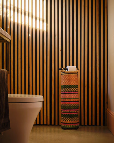 Hand woven tubular toilet roll holder in pink and green gingham pattern, artisan made in Ghana.