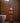 A handwoven multicolored toilet roll holder with a geometric pattern, placed in a bathroom setting.