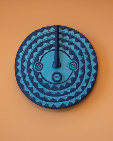 Blue decorative wall art, AARVEN mini sun mask in tonal blues with geometric patterns on an orange background