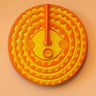 Decorative African mask in yellow and orange with geometric design on a peach background