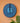 Blue decorative wall mask with geometric pattern on a peach wall.