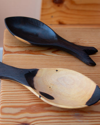 Wooden spoon shaped like a whale on a wooden surface