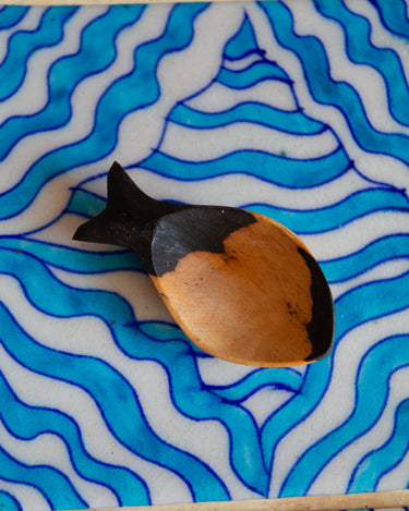 Decorative fish figure on a blue and white wavy patterned surface