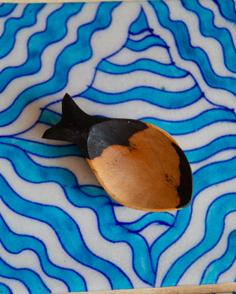 Decorative fish figure on a blue and white wavy patterned surface