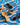Wooden and black spoons on a blue and white wavy-patterned surface