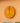 Decorative African sun mask in yellow and orange with geometric design on a peach wall