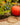 Gold bangles on a wooden surface with pumpkins and greenery in the background