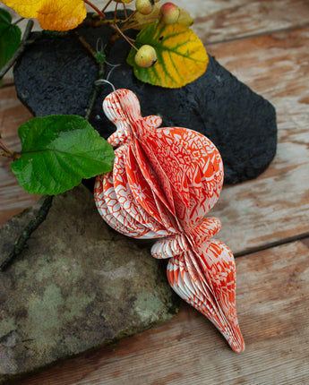 Large orange floral recycled paper decoration hanging at an eco-friendly party.