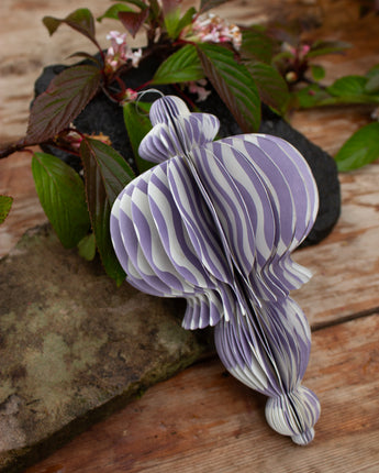 Large lilac wavey lines recycled paper decoration hanging at an eco-friendly party.