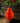 Orange paper ornament hanging against a decorative background with greenery and red berries.