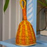 Woven rattle with orange and yellow pattern on a blue shelf