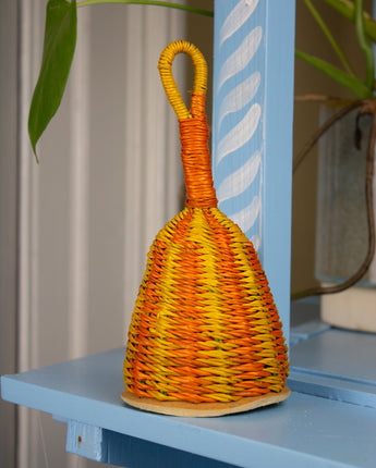 Woven rattle with orange and yellow pattern on a blue shelf