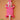 Decorative hand carved Ghanaian wall art with fluoro pink and white geometric patterns on a peach background