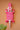 Decorative hand carved Ghanaian wall art with fluoro pink and white geometric patterns on a peach background