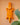 Orange geometric crocodile wall art, hand carved in Ghana, with a plant in the foreground on a peach background