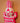 Hand carved fluoro pink and white geometric pattern Ghanaian crocodile mask. Close up on peach wall.
