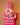 Hand carved fluoro pink and white geometric pattern Ghanaian crocodile mask. Close up on peach wall.
