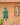 Green crocodile-shaped wall decoration on a peach-colored wall with a framed picture.