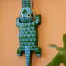 Green and blue geometric wall art crocodile carving, handmade by Ghanaian artisans on a peach background