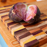 Two figs on a multicolored wooden cutting board