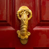 Gold lobster shaped novelty door knocker on a red door