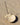 Shell incense holder by AARVEN with an incense stick on a sandy surface