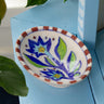 Decorative ceramic soap dish with floral design on a blue surface