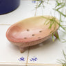 AARVEN handmade pink soapstone soap dish on a tiled surface.