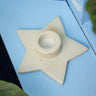 Star-shaped candle holder on a light blue surface
