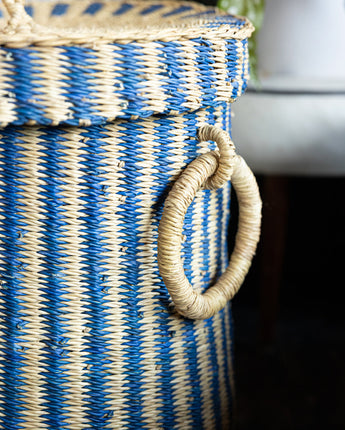 Handmade woven laundry basket with lid, crafted from natural materials.