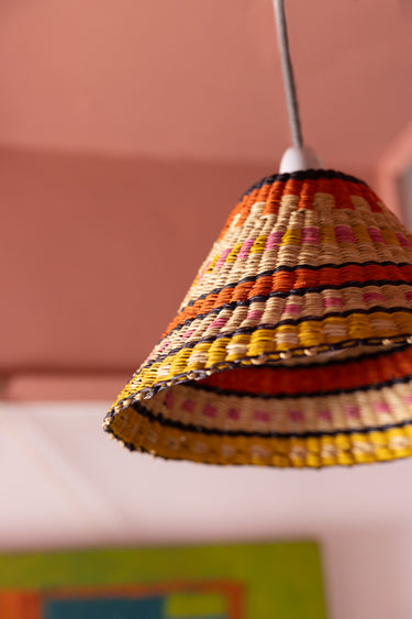 Close up of AARVEN Ghanaian Hand Woven Lightshade, cooli light shade in orange, pink, yellow and natural rattan, handwoven by artisans