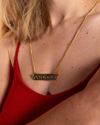 AARVEN Harakati necklace featuring bold brass geometric pattern.

