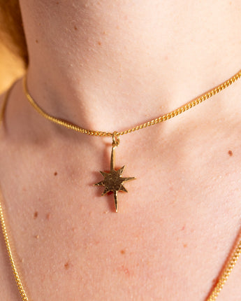 AARVEN Hammered Star necklace featuring a textured brass star pendant.