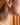 Close-up of a person wearing a gold star-shaped earring with a blurred background