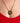 Gold necklace with a circular pendant on a person wearing a red garment.