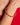 AARVEN hammered brass bangle worn by a person with a red garment in the background