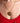 Gold necklace with a circular mixed metal pendant worn by a person in a red top.